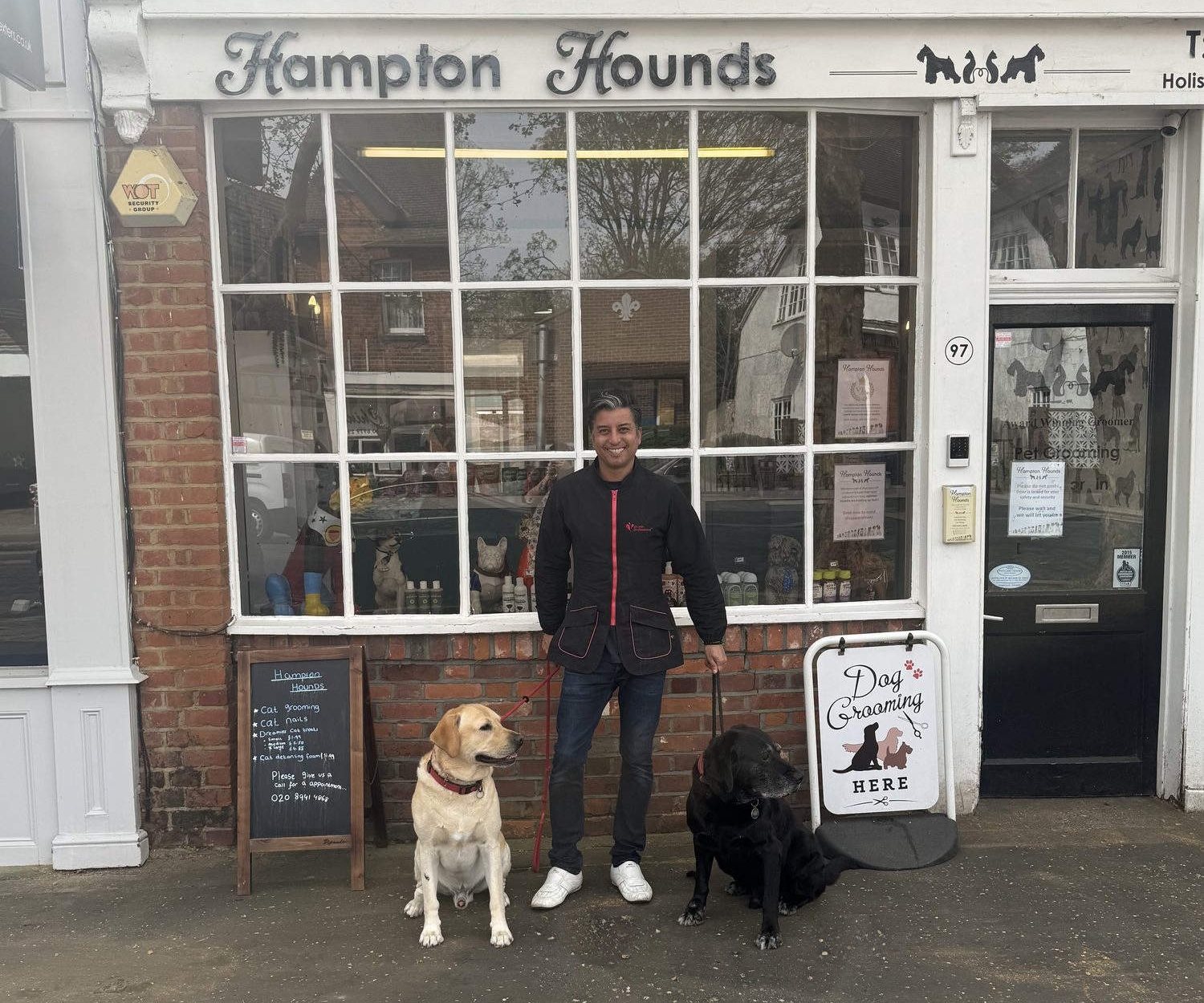 Thiago outside the Hampton Hounds salon on Station Road with two Labradors